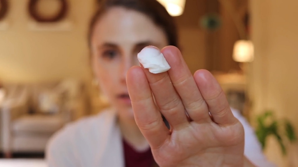 A woman has creams with ceramides on her finger