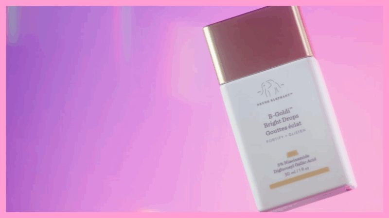 A bottle of Drunk Elephant D-Bronzi Anti-Pollution Sunshine Drops against a vibrant pink background