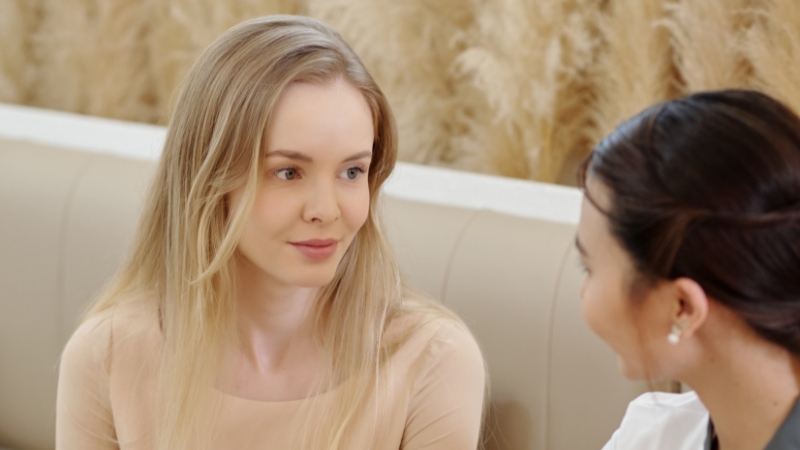 A spa professional talks with a client to plan personalized follow-ups after her appointment