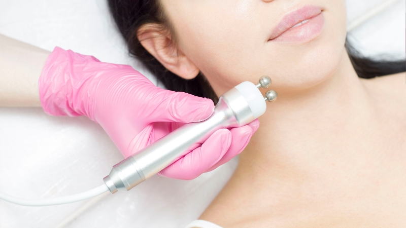 A professional performs radiofrequency skin tightening on a woman's neck to improve skin firmness safely