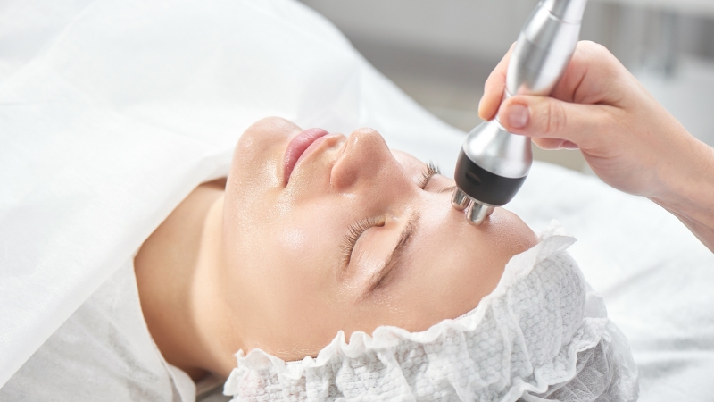 A person receives radiofrequency skin tightening on the forehead to help reduce wrinkles and firm the skin