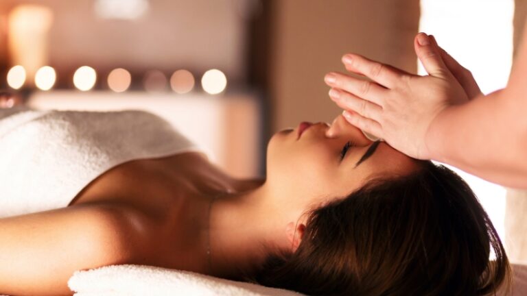 A woman receives a gentle facial massage in a spa setting during her post-treatment recovery session