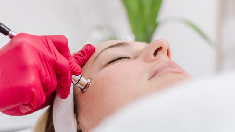 A woman receives a microdermabrasion treatment with a handheld device on her face