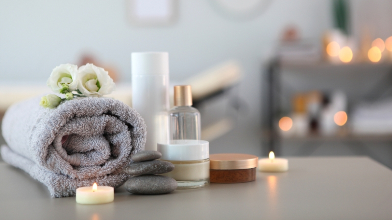 Spa treatment room setup with towels, skincare products, and candles