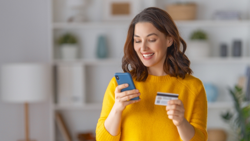 Woman with phone and card giving feedback on makeup products