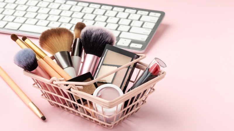 Basket of makeup products and brushes beside a keyboard showing online personalization