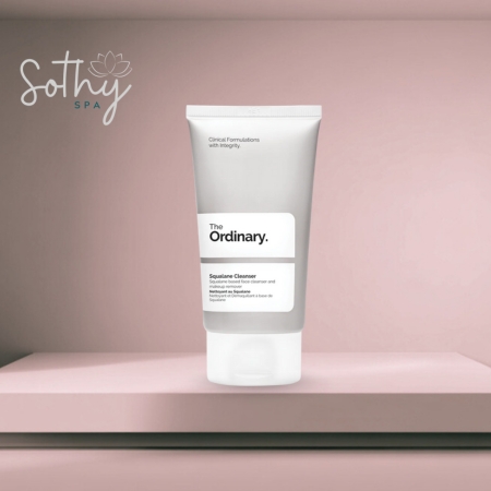 Tube of The Ordinary Squalane Cleanser displayed against a soft pink background with a spa logo