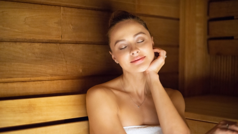 Woman relaxing in a sauna after skincare treatment, showing sauna after a facial