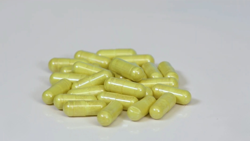 Yellow zinc supplement capsules arranged on a white surface